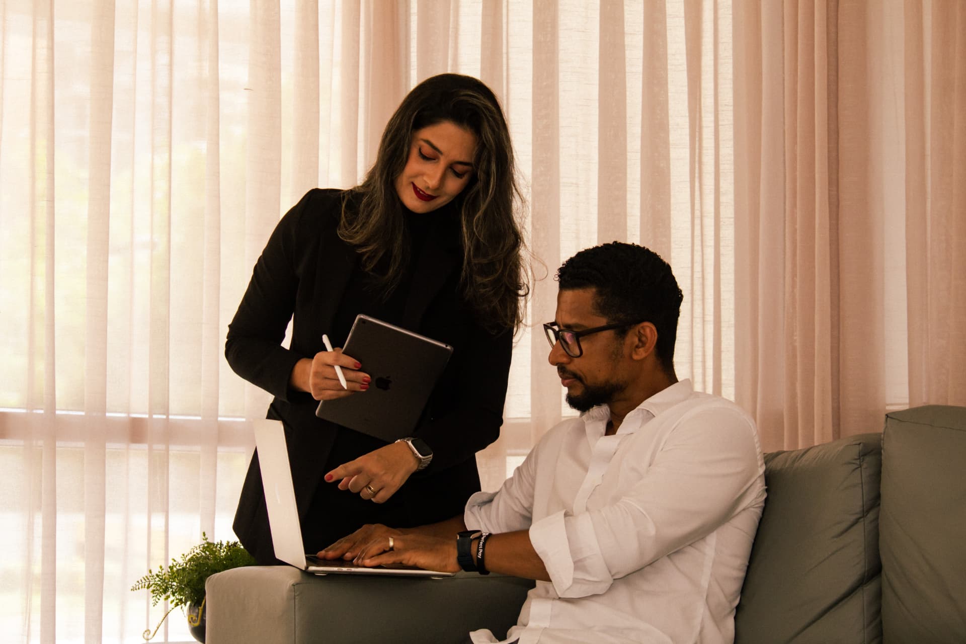 Caroline Lemos em atendimento, com tablet, ao lado de consultor no notebook